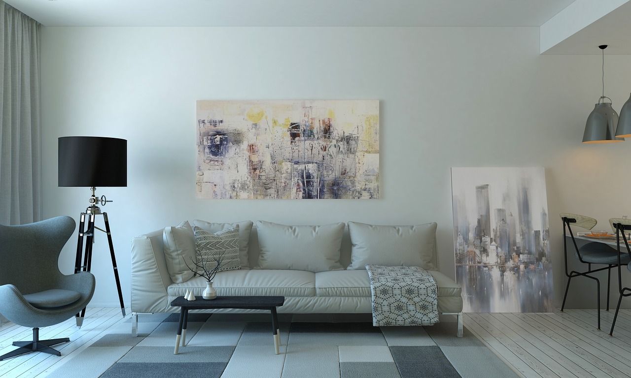 A quiet living room with a pale sofa, soft light and a large painting
